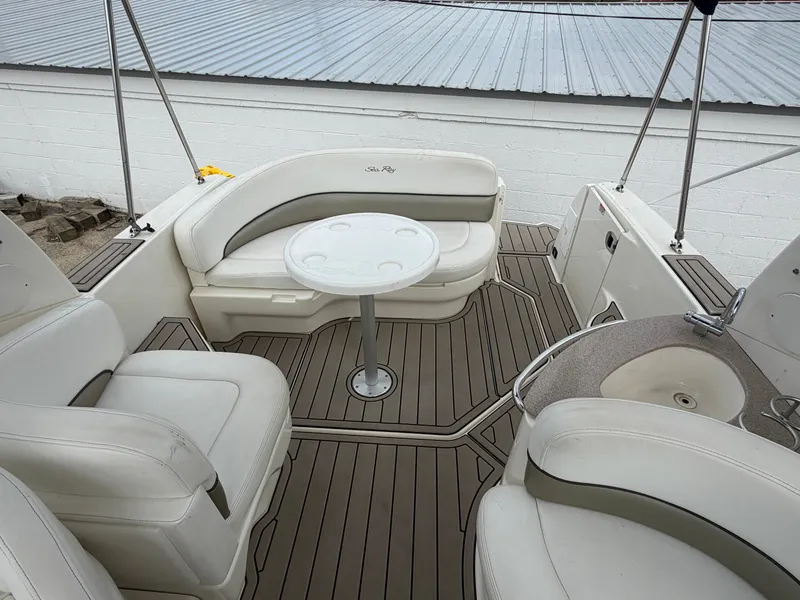 Slide: The Image of The image shows the cockpit of a 2006 Sea Ray Sundancer 260 with beige seating and a table. - 1