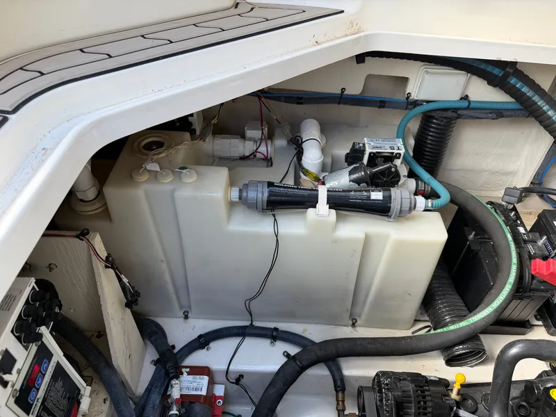Slide: The Image of A view of the engine compartment in a 2006 Sea Ray Sundancer 260, featuring various hoses and equipment. - 20