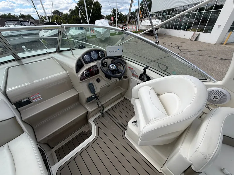 Slide: The Image of The cockpit of a 2006 Sea Ray Sundancer 260 with white seating and a steering console. - 6