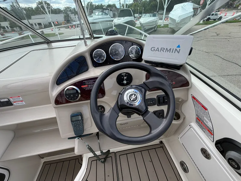 Slide: The Image of The image shows the helm of a 2006 Sea Ray Sundancer 260 with Garmin navigation. - 2