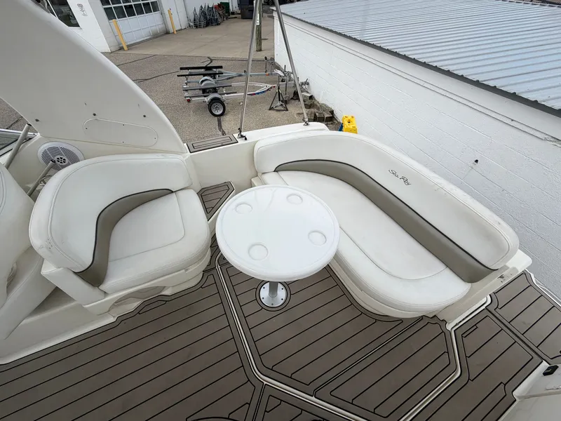 Slide: The Image of The image shows the cockpit of a 2006 Sea Ray Sundancer 260 with white seating and a round table. - 4