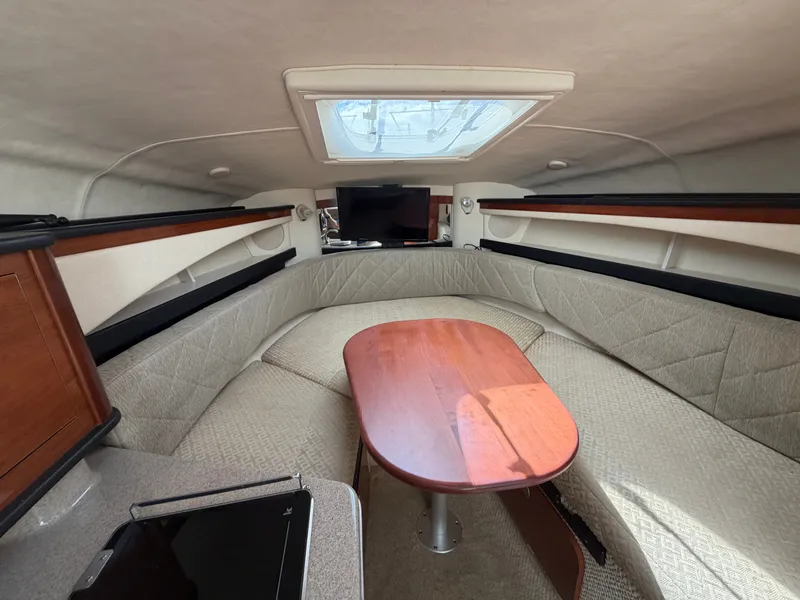 Slide: The Image of Interior of a 2006 Sea Ray Sundancer 260 with a cozy seating area and table. - 11