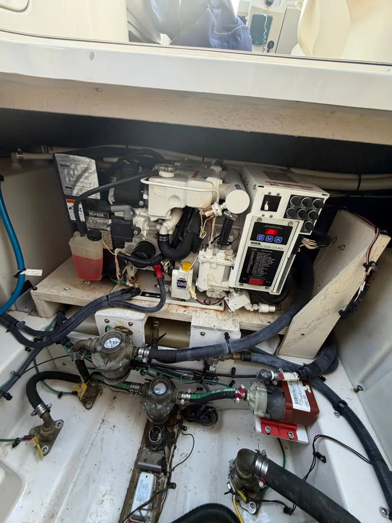 Slide: The Image of The engine compartment of a 2006 Sea Ray Sundancer 260 shows complex wiring and mechanics. - 18