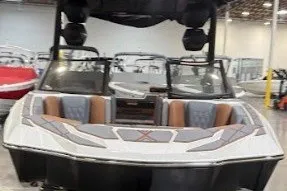Slide: The Image of 2026 Malibu M230 boat with sleek design and spacious seating in a showroom. - 10
