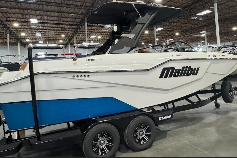 Slide: The Image of 2026 Malibu M230 boat on trailer in showroom, featuring sleek design and modern aesthetics. - 6