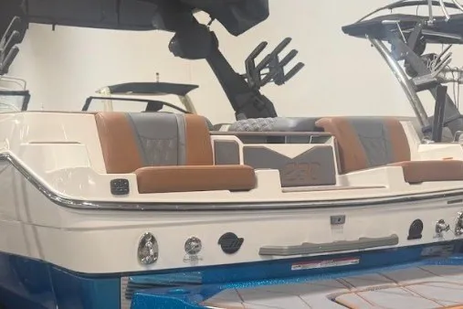 Slide: The Image of 2026 Malibu M230 boat with sleek design and comfortable seating in a showroom. - 12