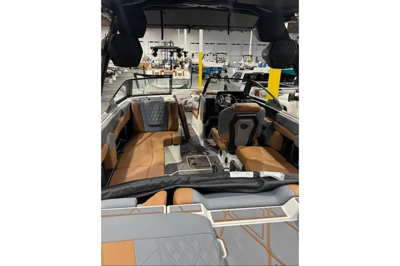 Slide: The Image of 2026 Malibu M230 boat interior with luxurious seating and modern design in a showroom. - 8