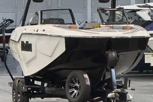 Slide: The Image of 2026 Malibu M230 boat on trailer in showroom, showcasing sleek design and modern features. - 5