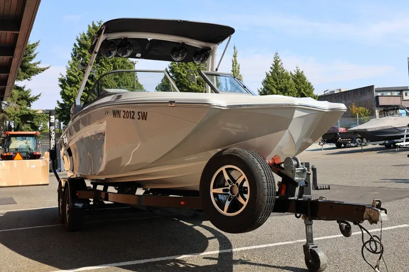 Slide: The Image of 2020 Tigé R20 boat on trailer, parked outdoors, with trees and buildings in the background. - 11