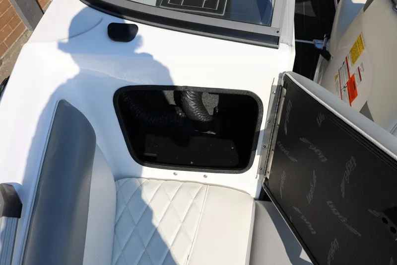 Slide: The Image of 2020 Tigé R20 boat interior storage compartment with open hatch and cushioned seating. - 49