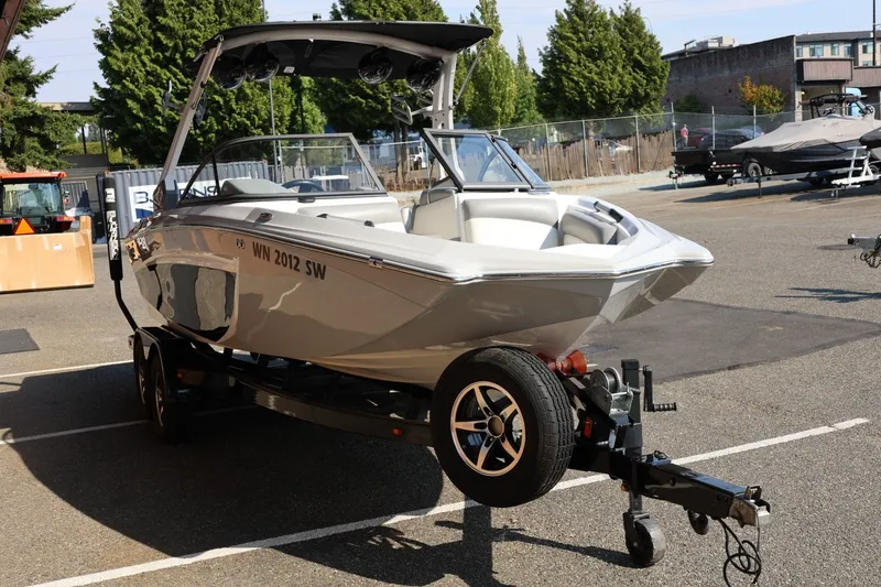 Slide: The Image of 2020 Tigé R20 boat on trailer in parking lot, surrounded by trees and buildings. - 10