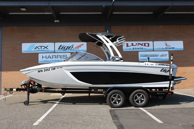 Slide: The Image of 2020 Tigé R20 boat on trailer, displayed outdoors with dealership signage in background. - 2