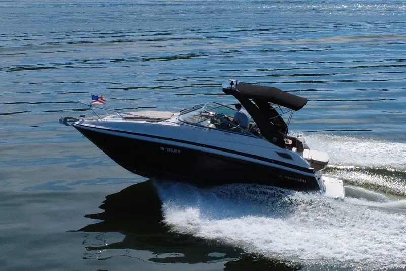 Slide: The Image of 2018 Regal 28 Express boat cruising on open water with American flag. - 28