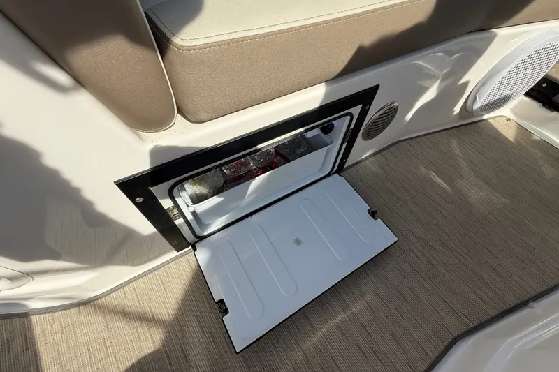 Slide: The Image of Open storage compartment on 2018 Regal 28 Express boat, revealing interior contents. - 17