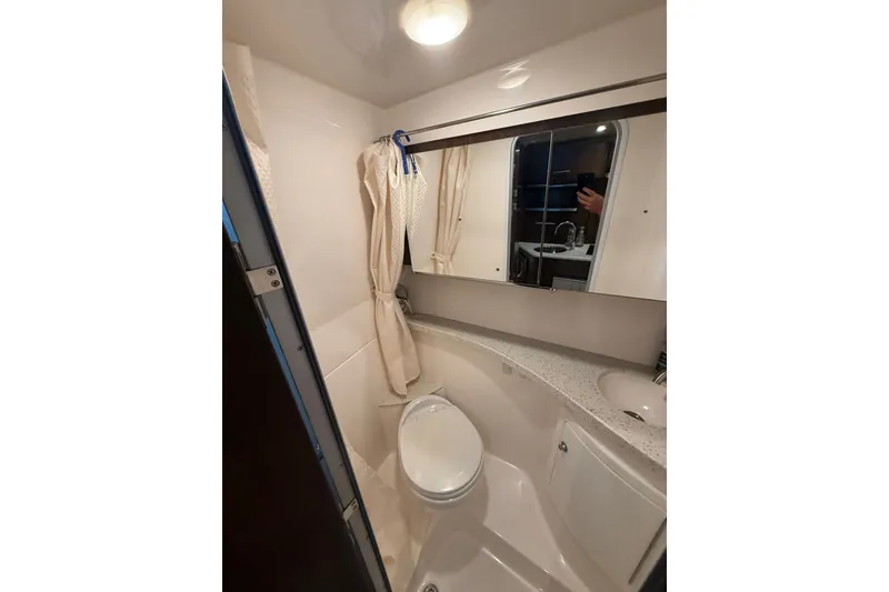 Slide: The Image of Bathroom interior of 2018 Regal 28 Express boat, featuring toilet, sink, and mirror. - 25