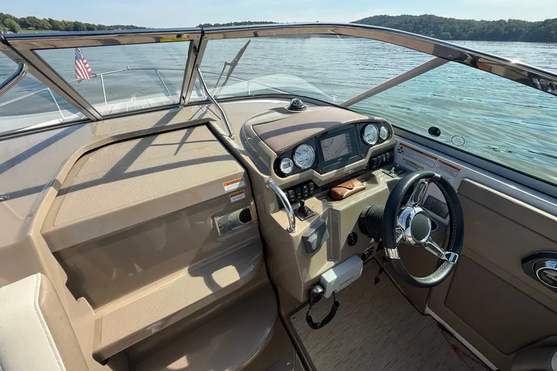 Slide: The Image of 2018 Regal 28 Express boat cockpit with steering wheel and dashboard on a sunny day. - 20
