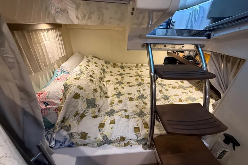 Slide: The Image of Cozy cabin interior of 2018 Regal 28 Express boat with bed and wooden steps. - 24