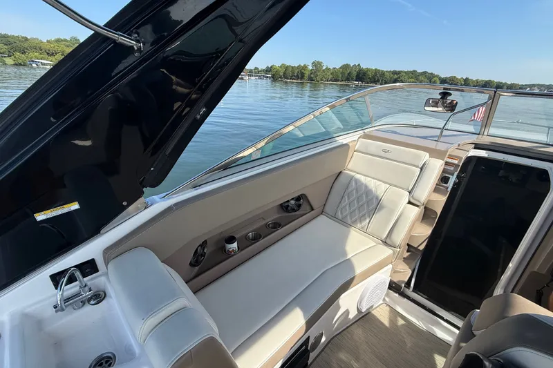 Slide: The Image of 2018 Regal 28 Express boat interior with plush seating and scenic lake view. - 18
