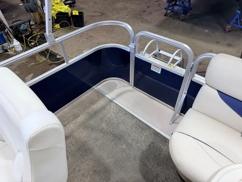 Slide: The Image of Interior view of a SunChaser pontoon boat with white seats and blue accents. - 34