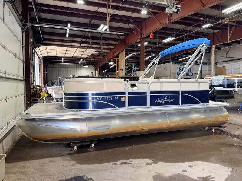 Slide: The Image of A 2015 SunChaser 8520 Classic Cruise pontoon boat with a 30HP Mercury 4Stroke EFI engine. It is in a warehouse with a blue sunshade. - 38
