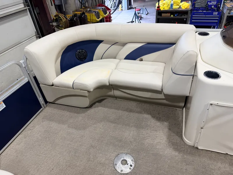 Slide: The Image of The image shows a white and blue cushioned seat in a boat with carpeted flooring. - 14