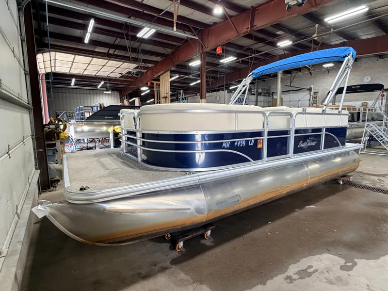 Slide: The Image of A 2015 SunChaser 8520 Classic Cruise pontoon boat with a blue canopy in a warehouse. - 37