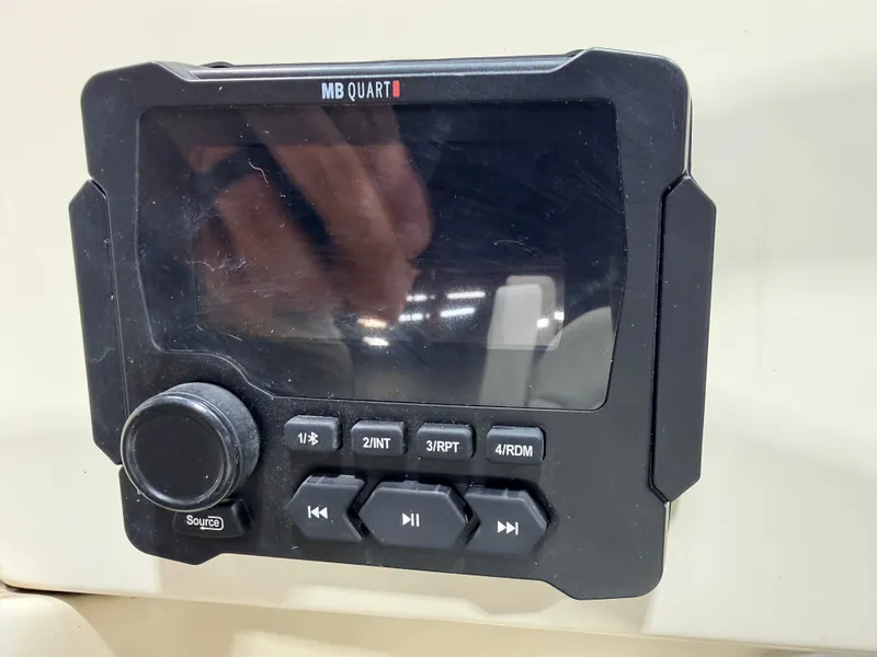 Slide: The Image of MB Quart control unit with multiple buttons and a dial. - 21
