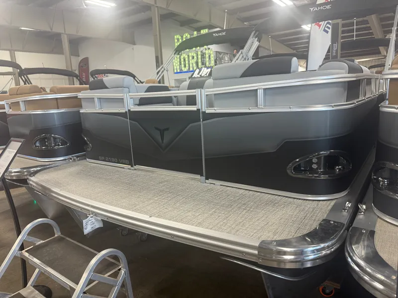 Slide: The Image of The image shows a modern pontoon boat with gray and black accents in a showroom. - 39