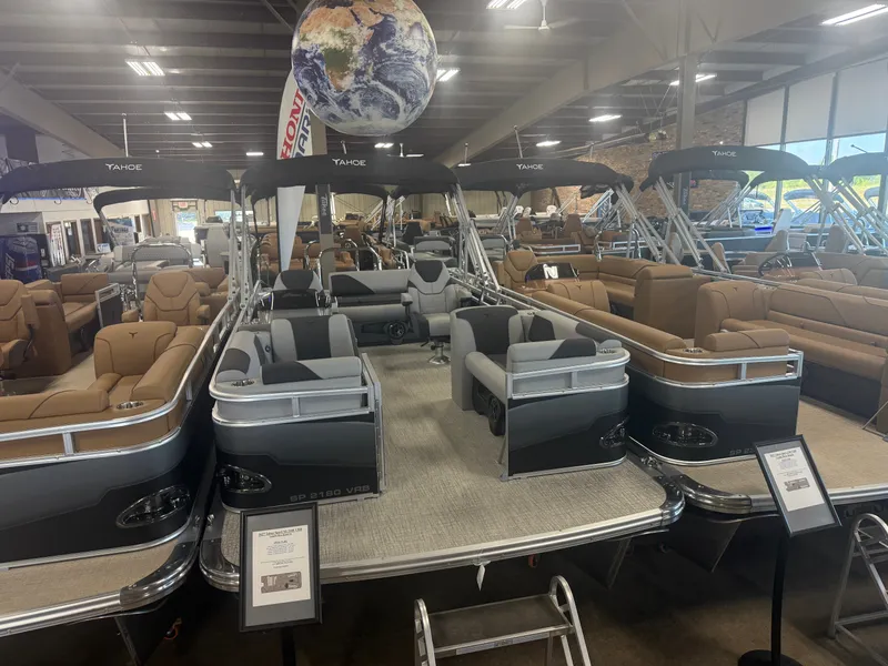 The Image of A modern pontoon boat showroom featuring several boats, including the Tahoe Sport VRB 2180 Swingback. - 1