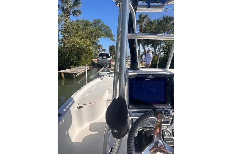 Slide: The Image of 2014 Blue Wave 2300 PureBay boat docked near a wooden pier with lush greenery. - 8