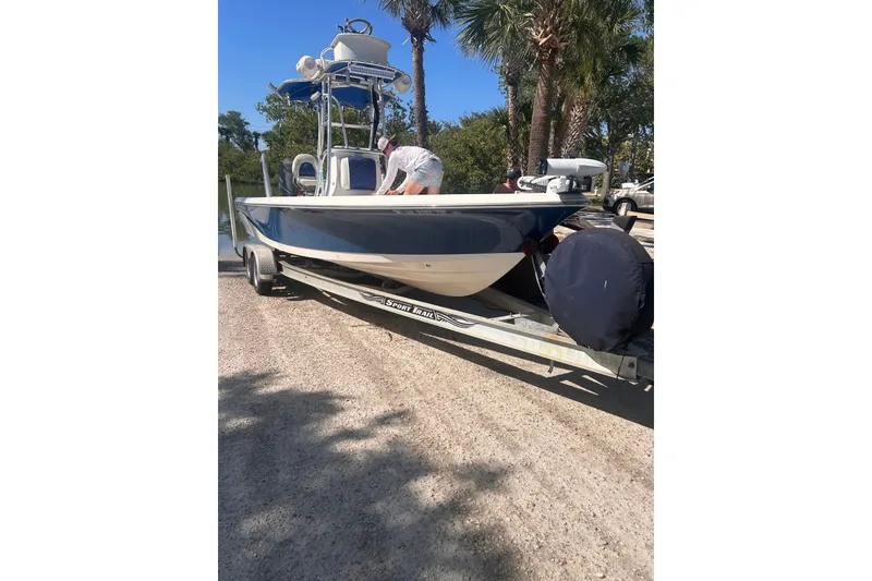 Slide: The Image of 2014 Blue Wave 2300 PureBay boat on trailer, parked near palm trees. - 6