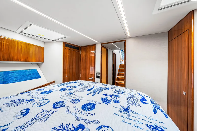 Slide: The Image of Luxurious interior of 2022 Riviera 505 SUV yacht with elegant wood finishes and nautical-themed bedding. - 13