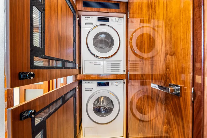 Slide: The Image of Laundry area inside 2022 Riviera 505 SUV yacht with stacked washer and dryer. - 10