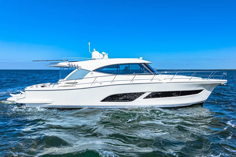 Slide: The Image of 2022 Riviera 505 SUV yacht cruising on open water under clear blue sky. - 2