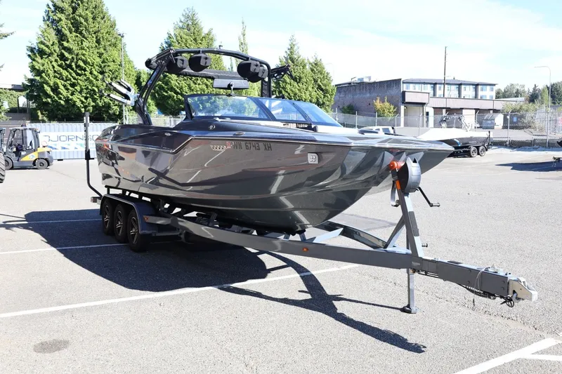 Slide: The Image of 2022 Supreme ZS252 boat on trailer in parking lot, surrounded by trees and buildings. - 10