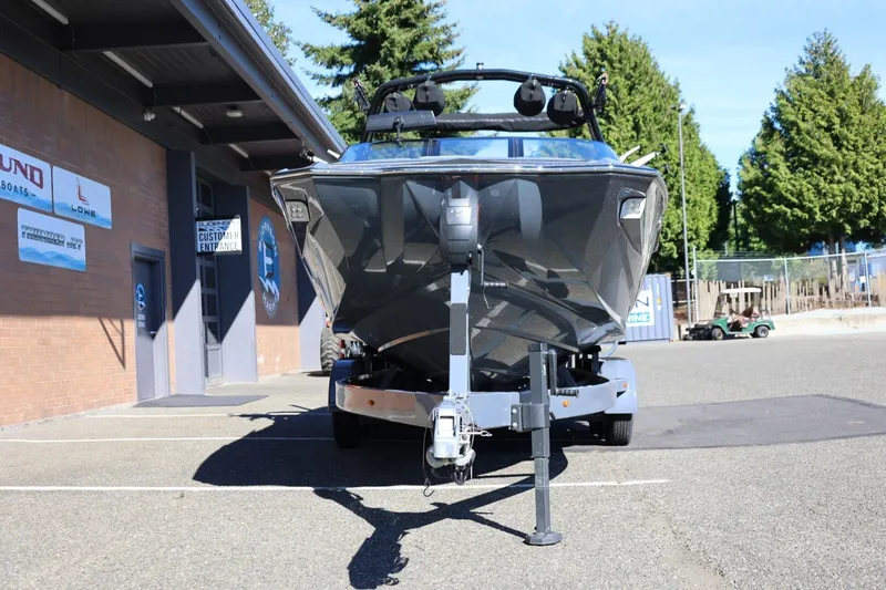 Slide: The Image of 2022 Supreme ZS252 boat on trailer outside a building, surrounded by trees. - 13