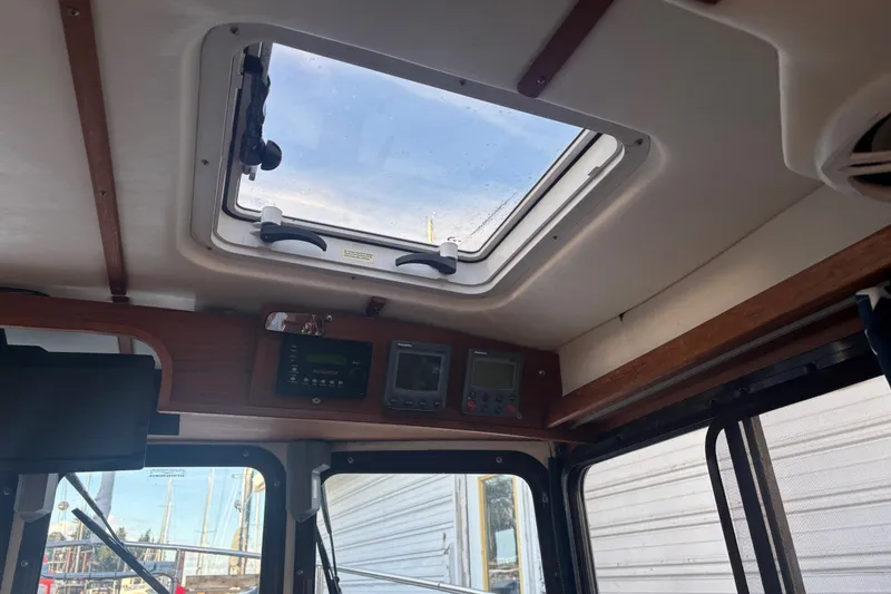 Slide: The Image of Interior view of a 2007 Ranger Tug R-25 boat with skylight and control panels. - 9