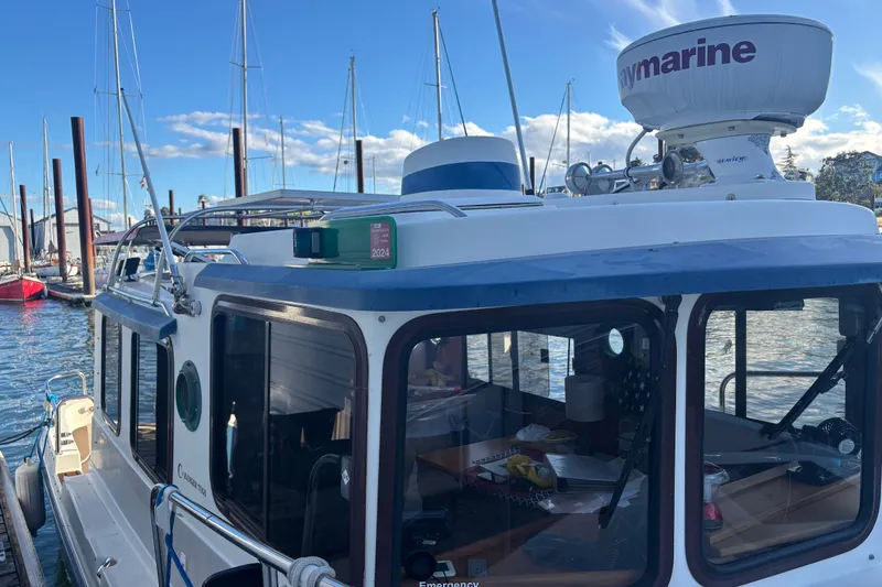Slide: The Image of 2007 Ranger Tug R-25 docked at marina, featuring Raymarine equipment and clear blue skies. - 1