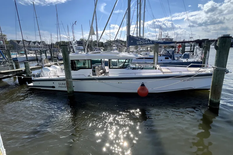 Slide: The Image of 2023 Axopar 37 XC Cross Cabin docked at a marina under a sunny sky. - 7
