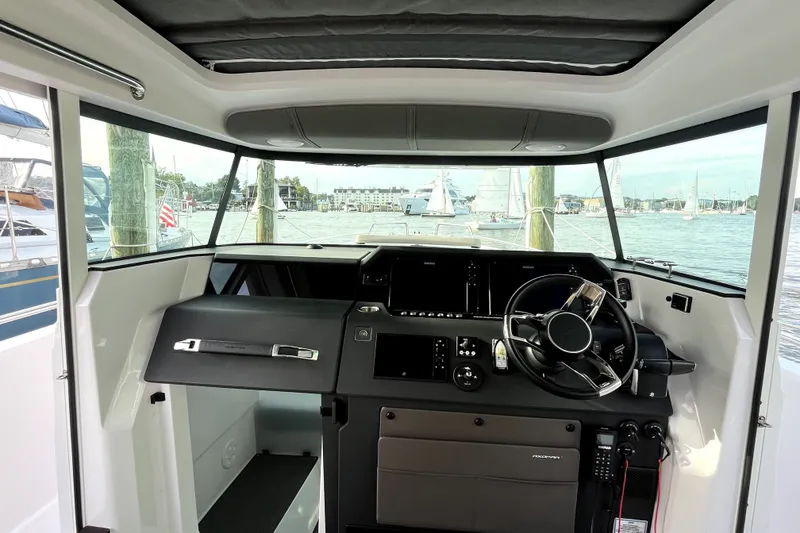 Slide: The Image of 2023 Axopar 37 XC Cross Cabin interior with steering wheel and dashboard view. - 15