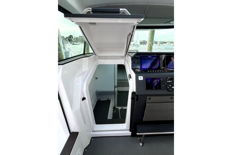 Slide: The Image of 2023 Axopar 37 XC Cross Cabin interior with open hatch and navigation screens. - 20