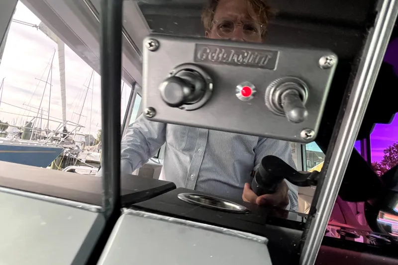Slide: The Image of Control panel inside 2023 Axopar 37 XC Cross Cabin, with marina view in background. - 19