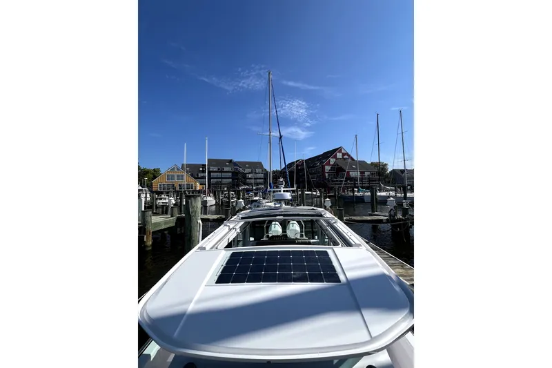 Slide: The Image of 2023 Axopar 37 XC Cross Cabin docked at a marina under a clear blue sky. - 45
