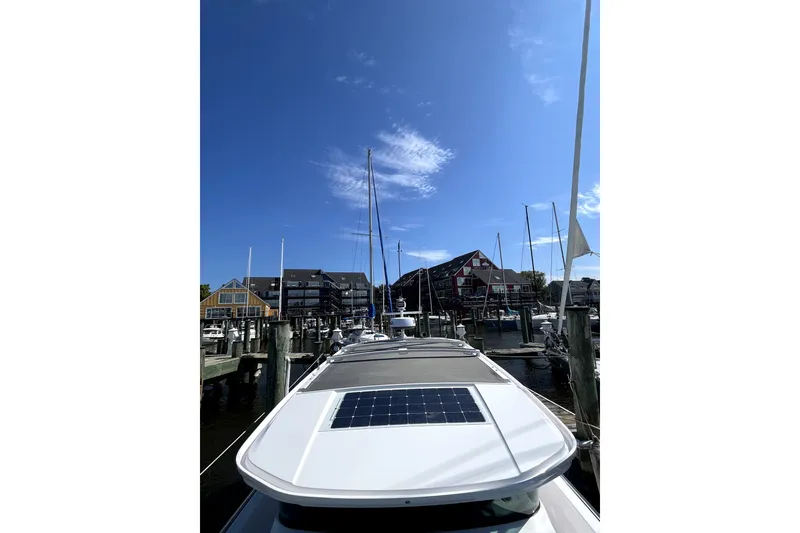 Slide: The Image of 2023 Axopar 37 XC Cross Cabin docked at a marina under a clear blue sky. - 46
