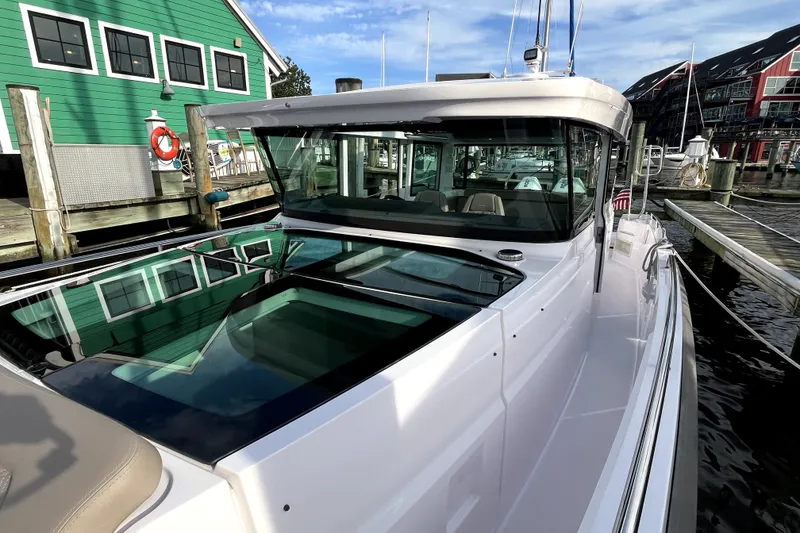 Slide: The Image of 2023 Axopar 37 XC Cross Cabin docked at marina, showcasing sleek design and modern features. - 9