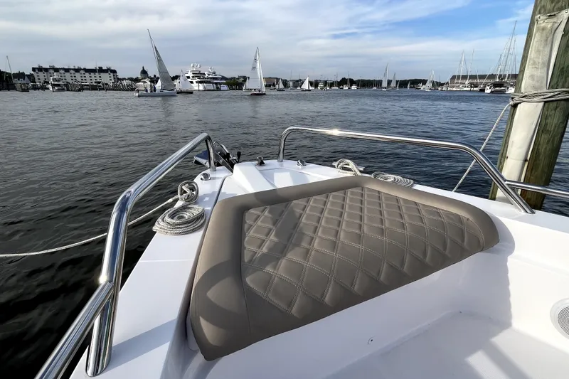 Slide: The Image of 2023 Axopar 37 XC Cross Cabin boat with cushioned seating, docked in a marina. - 30