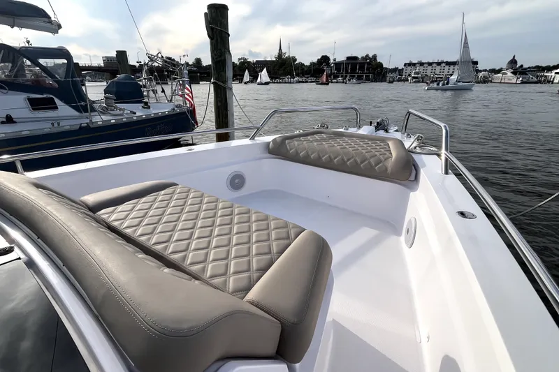 Slide: The Image of 2023 Axopar 37 XC Cross Cabin boat with luxurious seating, docked in a scenic marina. - 29
