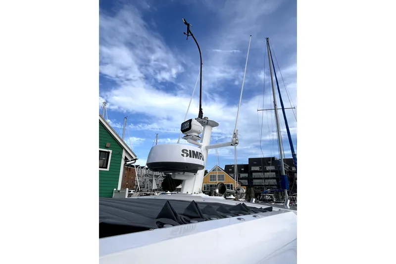 Slide: The Image of 2023 Axopar 37 XC Cross Cabin with radar equipment against a blue sky. - 44