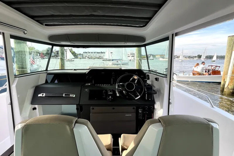 Slide: The Image of Interior view of 2023 Axopar 37 XC Cross Cabin, showcasing helm and waterfront scenery. - 14