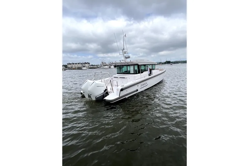 Slide: The Image of 2023 Axopar 37 XC Cross Cabin boat on calm water under cloudy sky. - 6